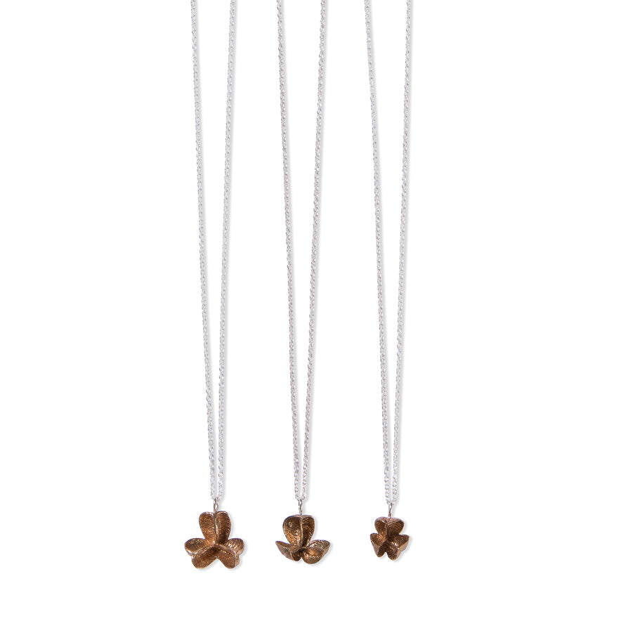three different sizes of single bronze spikethorn pendant by Tiffany Marx on a silver chain
